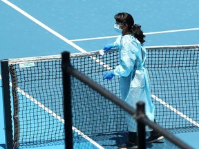 A staff member wearing PPE works to clean surfaces at Melbourne Park in between training sessions for tennis players undergoing mandatory quarantine in advance of the Australian Open in Melbourne, Australia, January 21, 2021.