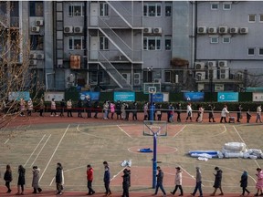People line up to get their nucleic acid test on the sports ground of a school following the outbreak of the coronavirus disease (COVID-19) in Beijing, China, January 22, 2021.
