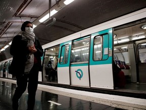 People wearing protective face masks walk on a platform at a metro station of Paris transport network (RATP) in Paris as France softens its strict lockdown rules during the outbreak of the coronavirus disease (COVID-19) in France, May 11, 2020.