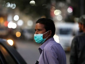 A man wearing a protective mask walks outside a shopping area, as the outbreak of coronavirus disease (COVID-19) continues, in Karachi, Pakistan December 29, 2020.