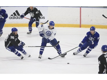 Toronto Maple Leafs Ilya Mikheyev RW (65) pushes the puck past Rasmus Sandin D (38) and Alexander Barabanov LW (94) at practice in Toronto on Tuesday January 12, 2021. Jack Boland/Toronto Sun/Postmedia Network