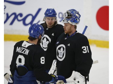 Toronto Maple Leafs Frederik Andersen G (31) has a little talk with Jake Muzzin D (8) along with Justin Holl (3) during a break in the action at practice in Toronto on Tuesday January 12, 2021. Jack Boland/Toronto Sun/Postmedia Network