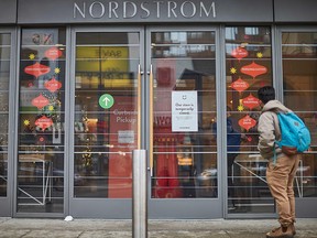 A man stands in front of the Nordstrom store, closed for in-store shopping in downtown Toronto, on November 23, 2020.