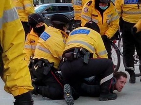 A protester is arrested by police during an anti-lockdown demonstration on Jan. 23, 2021 at Yonge-Dundas Square.