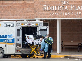 Paramedics transport a person from Roberta Place, a long-term care facility in Barrie that is the site of a COVID-19 outbreak, on Jan. 18, 2021.