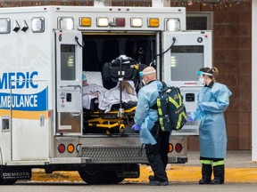 Paramedics transport a person from Roberta Place, a long-term care facility that is the site of a COVID-19 outbreak in Barrie on Jan. 18, 2021.