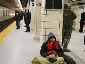 Sean Boyd, who has called the subway platform home for at least six weeks, panhandles at the Yonge and Bloor TTC station on Thursday, Jan. 28, 2020.
