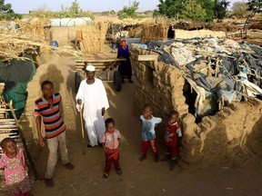 An internally displaced Sudanese family poses for a photograph outside their makeshift shelter within the Kalma camp for internally displaced persons (IDPs) in Darfur, Sudan April 26, 2019.