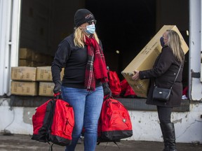 Jody Steinhauer (left), president of Bargains Group and founder of Engage and Change, helps to distribute some of the 3,000 Winter Survival Kits during the 22nd annual Engage and Change's Project Winter Survival from a warehouse on 501 Alliance Ave. in Toronto, Ont. on Saturday, Jan. 16, 2021.