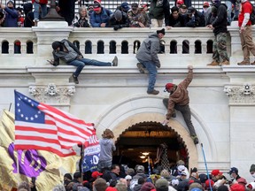 A mob of supporters of U.S. President Donald Trump fight with members of law enforcement at a door they broke open as they storm the U.S. Capitol Building in Washington, January 6, 2021.