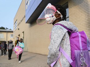 Five year-old Nancy Murphy wears a full mask and face shield as she waits in line for her kindergarten class to enter the school at Portage Trail Community School which is part of the Toronto District School Board (TDSB) during the COVID-19 pandemic in Toronto on Tuesday, September 15, 2020.