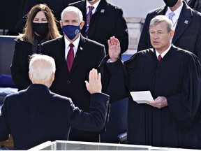 John Roberts, chief justice of the U.S. Supreme Court, right, administers the oath of office to U..S. President-elect Joe Biden, second left, during the inauguration ceremony on the West Front of the U.S. Capitol on January 20, 2021 in Washington, DC.