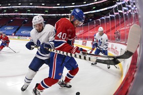 Alexander Kerfoot of the Maple Leafs (left) and Joel Armia of the Canadiens battle for the puck along the boards during the second period at the Bell Centre on Feb. 10, 2021 in Montreal, Canada. Minas Panagiotakis/Getty Images