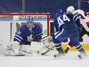 Evgenii Dadonov of the Ottawa Senators scores the game-winning goal under pressure from Maple Leafs' Morgan Rielly as goaltender Frederik Andersen tries to stop him during overtime during at Scotiabank Arena on Monday, Feb. 15, 2021 in Toronto.