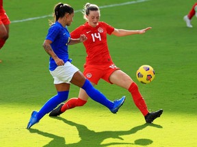 Jullia Blanchi (No.13) fights for the ball with Gabrielle Carle (No. 14) of Canada during a match at the SheBelieves Cup at Exploria Stadium in Orlando, Fla., on Feb. 24, 2021.