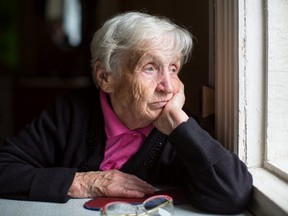 A depressed senior looks out the window
