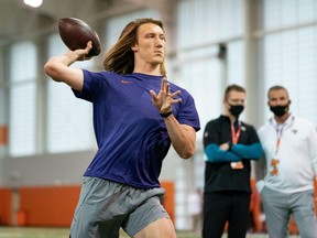 Ex-Clemson Tigers quarterback Trevor Lawrence works out as Jacksonville Jaguars head coach Urban Meyer (right) looks on during Pro Day in Clemson.