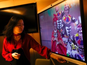 Liu Yuting controls the screen while watching the Lunar New Year gala after having dinner with her family at a Haidilao hotpot restaurant, in Beijing, China, Feb. 11, 2021.