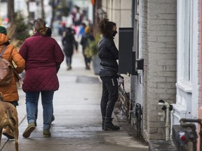 A woman orders take-out coffee along Queen St. W. near Trinity Bellwoods Park in Toronto on Feb. 28, 2021.