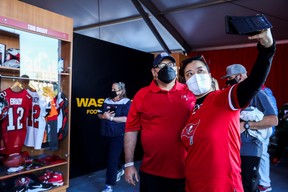 Tampa Bay Buccaneers fans pose for a photo in front of a recreation of Tom Brady’s locker at the gallery at The Super Bowl Experience Presented By Lowe?s event ahead of the weekend’s Super Bowl LV between the Kansas City Chiefs and Tampa Bay Buccaneers in Tampa Bay February 3, 2021.