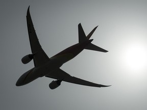 A plane is silhouetted as it takes off from Vancouver International Airport in Richmond, B.C.