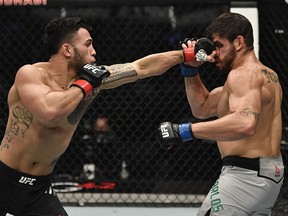 Brad Tavares punches Antonio Carlos Junior in a middleweight fight during UFC 257 inside Etihad Arena on UFC Fight Island.