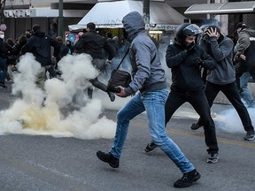 Protesters run away from tear gas during a demonstration in Athens on February 24, 2021 in support to a jailed far left group member on hunger strike for 48 days.