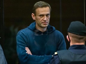 Russian opposition leader Alexei Navalny, charged with violating the terms of a 2014 suspended sentence for embezzlement, stands inside a glass cell during a court hearing in Moscow on Tuesday, Feb. 2, 2021.