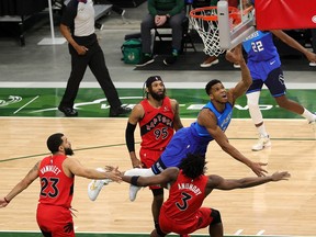 A number of Raptors, including DeAndre' Bembry (top) defend two-time NBA MVP Giannis Antetokounmpo.