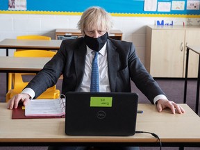 British Prime Minister Boris Johnson takes part in an online class during his visit to the Sedgehill School, in London, February 23, 2021.