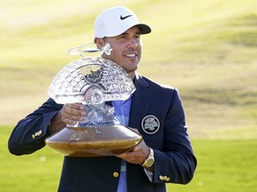 Brooks Koepka poses with the trophy after winning the Waste Management Phoenix Open at TPC Scottsdale in Scottsdale, Ariz., Feb. 7, 2021.