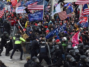 In this file photo taken on January 6, 2021 Trump supporters clash with police and security forces as they push barricades to storm the U.S. Capitol in Washington.