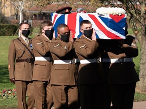 The coffin is carried by members of the Armed Forces during the funeral service of Captain Tom Moore at Bedford Crematorium in Bedford, north of London on Feb. 27, 2021.