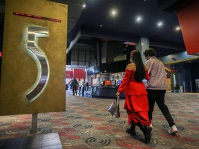 People walk in a cinema as Quebec allows the reopening of movie theatres but not the selling of food and drinks, which includes popcorn, during the outbreak of the COVID-19 in Montreal, Feb. 27, 2021.