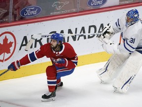 Maple Leafs goaltender Frederik Andersen plays the puck ahead of Montreal Canadiens' Phillip Danault during first-period action in Montreal on Wednesday, Feb. 10, 2021.