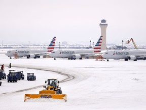 Crews use plows to clear snow from American Airlines Terminal C at Dallas-Fort Worth International Airport, Wednesday, Feb. 17, 2021, in Dallas.