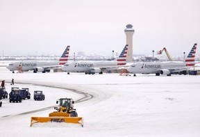 Crews use plows to clear snow from American Airlines Terminal C at Dallas-Fort Worth International Airport, Wednesday, Feb. 17, 2021, in Dallas.