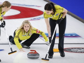 Lead Lisa Weagle of Team Manitoba gets ready to follow skip Jennifer Jones’ shot against British Columbia during yesterday’s match at the Scotties Tournament of Hearts in Calgary.
