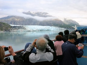 Passengers look out at Margerie Glacier as the ship cruises through Glacier Bay National Park, Alaska.