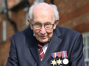 In this file photo taken April 16, 2020, British World War II veteran Captain Tom Moore poses doing a lap of his garden in the village of Marston Moretaine.