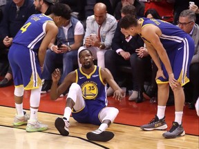 Kevin Durant, then of the Golden State Warriors, reacts after sustaining an injury during Game Five of the 2019 NBA Finals at Scotiabank Arena in Toronto on June 10, 2019.
