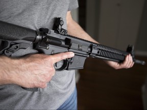 A restricted gun licence holder holds a AR-15 at his home in Langley, B.C. on May 1, 2020.