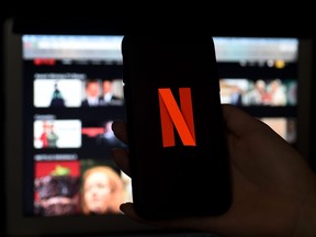 In this photo illustration a computer and a mobile phone screens display the Netflix logo on March 31, 2020 in Arlington, Va.