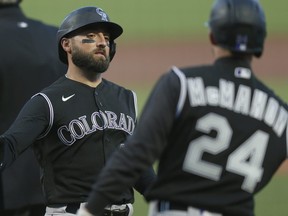 Kevin Pillar, left, of the Colorado Rockies celebrates with Ryan McMahon after scoring on a single hit by Josh Fuentes #8 in the top of the first inning against the San Francisco Giants at Oracle Park on Sept. 21, 2020 in San Francisco, Calif.