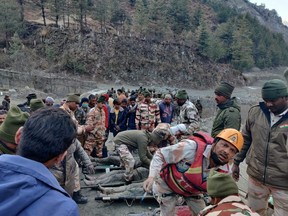 Members of Indo-Tibetan Border Police tend to people rescued after a Himalayan glacier broke and swept away a small hydroelectric dam, in Chormi village in Tapovan in the northern state of Uttarakhand, India, Sunday, Feb. 7, 2021.