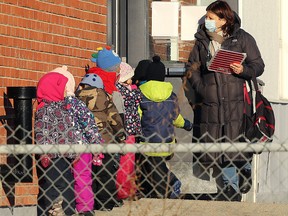 Children queue to return indoors at John Dafoe School in Winnipeg on Dec. 2, 2020.