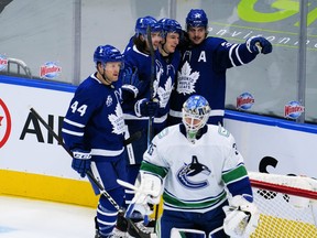 Maple Leafs' Auston Matthews (34) celebrates his second goal of the game against Vancouver Canucks goaltender Thatcher Demko with forward Zach Hyman (11) and defencemen Justin Holl (3) and Morgan Rielly (44) during the second period at Scotiabank Arena on Thursday, Feb. 4, 2021.