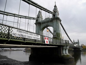 A warning sign is seen attached to Hammersmith Bridge in London, November 26, 2020