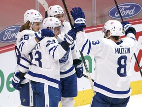 Maple Leafs defenceman Travis Dermott (23) celebrates his goal against the Montreal Canadiens with teammates on Feb. 10 at the Bell Centre.