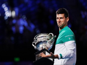 This handout photo released by the Tennis Australia on Feb. 21, 2021 shows Serbia's Novak Djokovic celebrating with the Norman Brookes Challenge Cup trophy after beating Russia's Daniil Medvedev to win their men's singles final match at the Australian Open tournament in Melbourne.